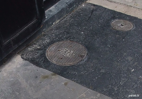 Goudron récent autour des plaques en fonte pour le gaz. Goudron récent autour des plaques en fonte pour le gaz.