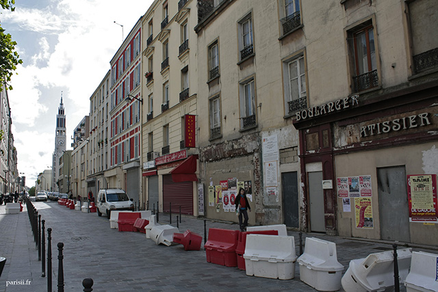 Une rue du 20e arrondissement, avec des immeubles aux portes murées