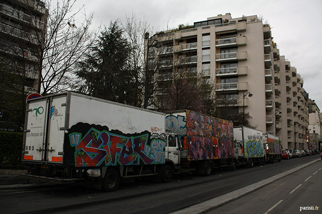 Tags sur des camions, stationnés devant des tours d'habitation parisiennes